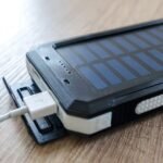 solar powered phone charger charging a device via USB cable, illustrating portable solar charging for phones