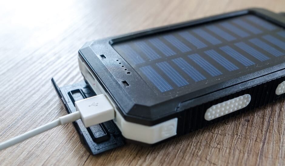 solar powered phone charger charging a device via USB cable, illustrating portable solar charging for phones