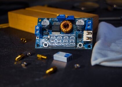 Close-up of a DC to DC charger circuit board with digital display and components, illustrating RV charger selection.