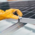 Gloved hand adjusting a solar panel tilt mount bracket, illustrating RV solar panel mounting options for optimal angle.