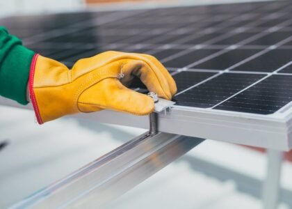 Gloved hand adjusting a solar panel tilt mount bracket, illustrating RV solar panel mounting options for optimal angle.