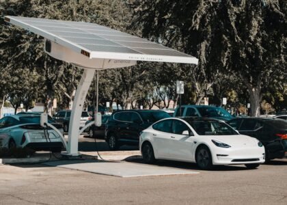 solar charge controller use shown by a solar-powered EV charging station with electric cars parked underneath in a lot