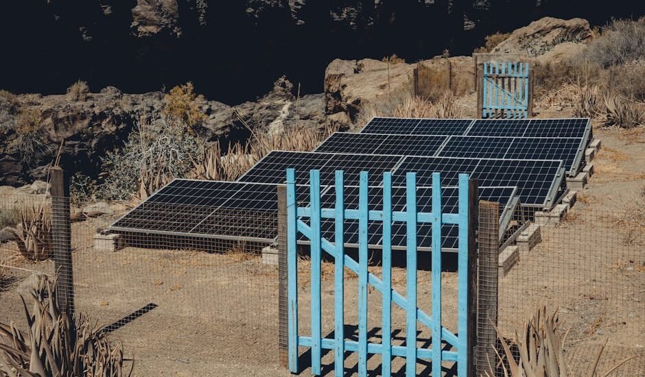 Solar charge controller functions illustrated by ground-mounted solar panels behind a blue gate in a dry, rocky area