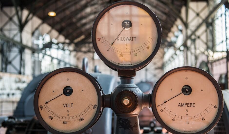 Three vintage analog meters labeled volt, ampere, and kilowatt illustrate the difference between amp hours and watt hours.