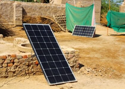 Two different solar panel systems set up outdoors on bare ground, illustrating choices for off-grid power solutions.