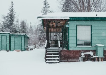 A snowy scene featuring a green cabin and storage sheds, relevant to dual fuel generators.