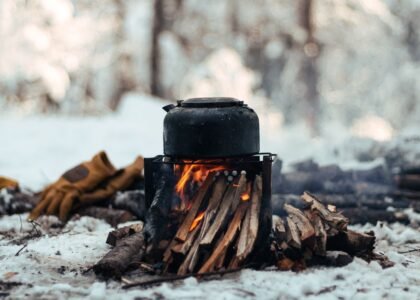 A campfire setup with a kettle on top, illustrating outdoor heating methods relevant to battery-operated heaters.