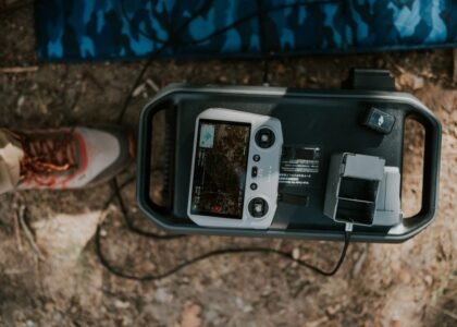 A portable 12V battery charger with a display and charging ports on a surface.