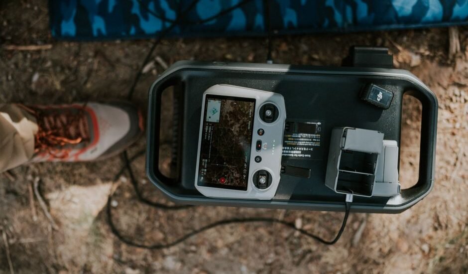 A portable 12V battery charger with a display and charging ports on a surface.