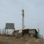 Image showing solar panels and a communication tower, relevant to high and low frequency inverters.