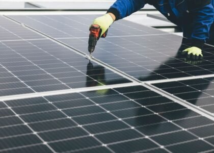 A worker installs solar panels, relevant to high-capacity lithium-ion batteries.