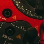 A close-up of a multimeter showing settings for measuring appliance power consumption.