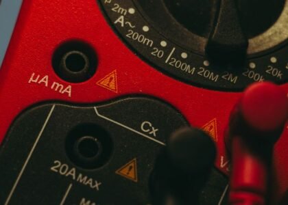 A close-up of a multimeter showing settings for measuring appliance power consumption.