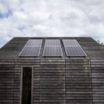 Image showing solar panels on a wooden cabin, relevant to portable vs standby generators.