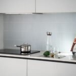 A sleek kitchen with a 12V induction cooktop, pot, and kitchen accessories.