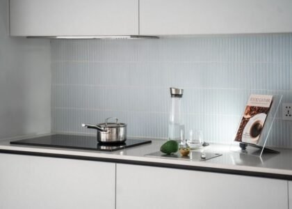A sleek kitchen with a 12V induction cooktop, pot, and kitchen accessories.