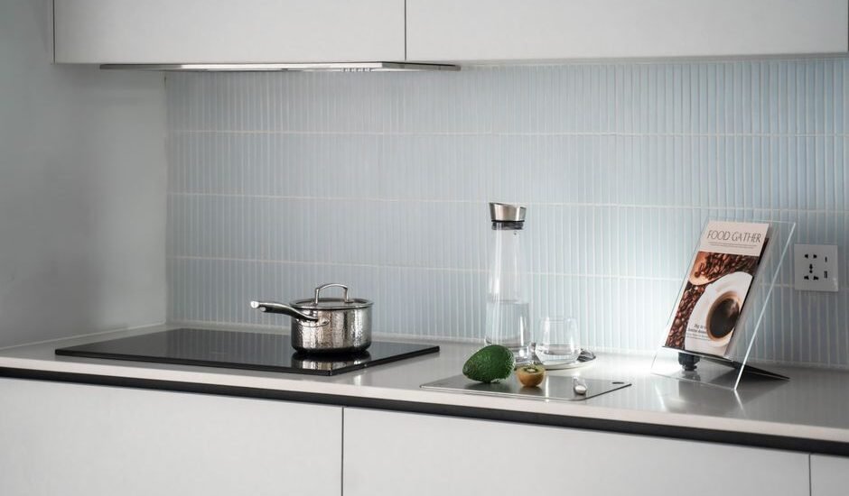 A sleek kitchen with a 12V induction cooktop, pot, and kitchen accessories.