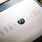 Control panel of a small 12V air conditioner showing temperature and settings.