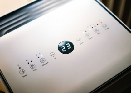 Control panel of a small 12V air conditioner showing temperature and settings.