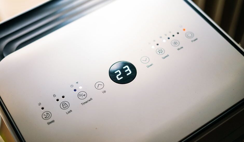Control panel of a small 12V air conditioner showing temperature and settings.