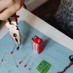 A person using pliers to work on battery components, illustrating how to balance battery cells.