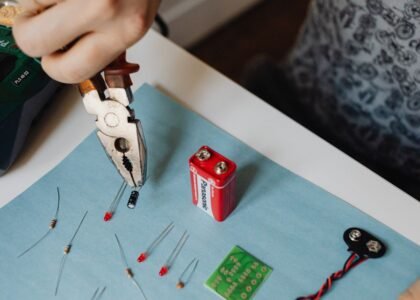 A person using pliers to work on battery components, illustrating how to balance battery cells.