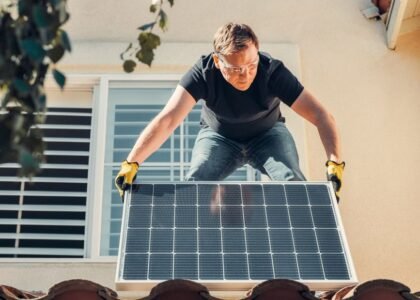 A person adjusting the angle of a solar panel on a roof, relevant to optimizing solar panel angle.