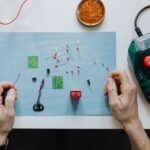Hands working on electronic components for repairing a portable power station.
