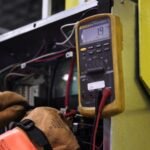 A person testing generator output voltage using a multimeter, illustrating the process described in the article.