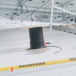 A spool of black wire on a solar panel setup, illustrating how to wire multiple solar panels.
