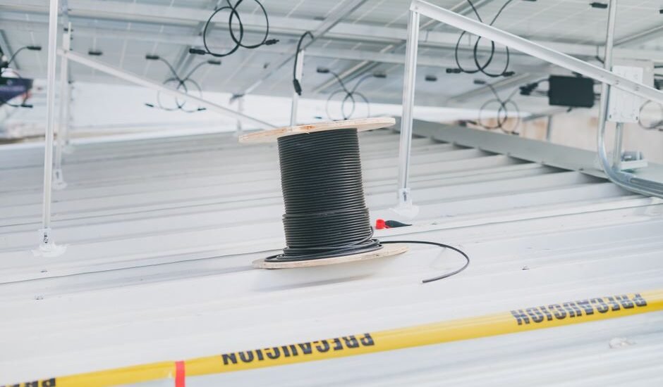 A spool of black wire on a solar panel setup, illustrating how to wire multiple solar panels.